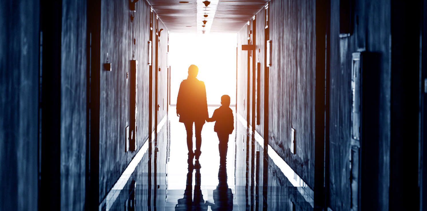 Mother And Child Holding Hands In Hallway