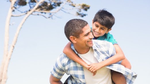 A man carrying a young boy on his back.