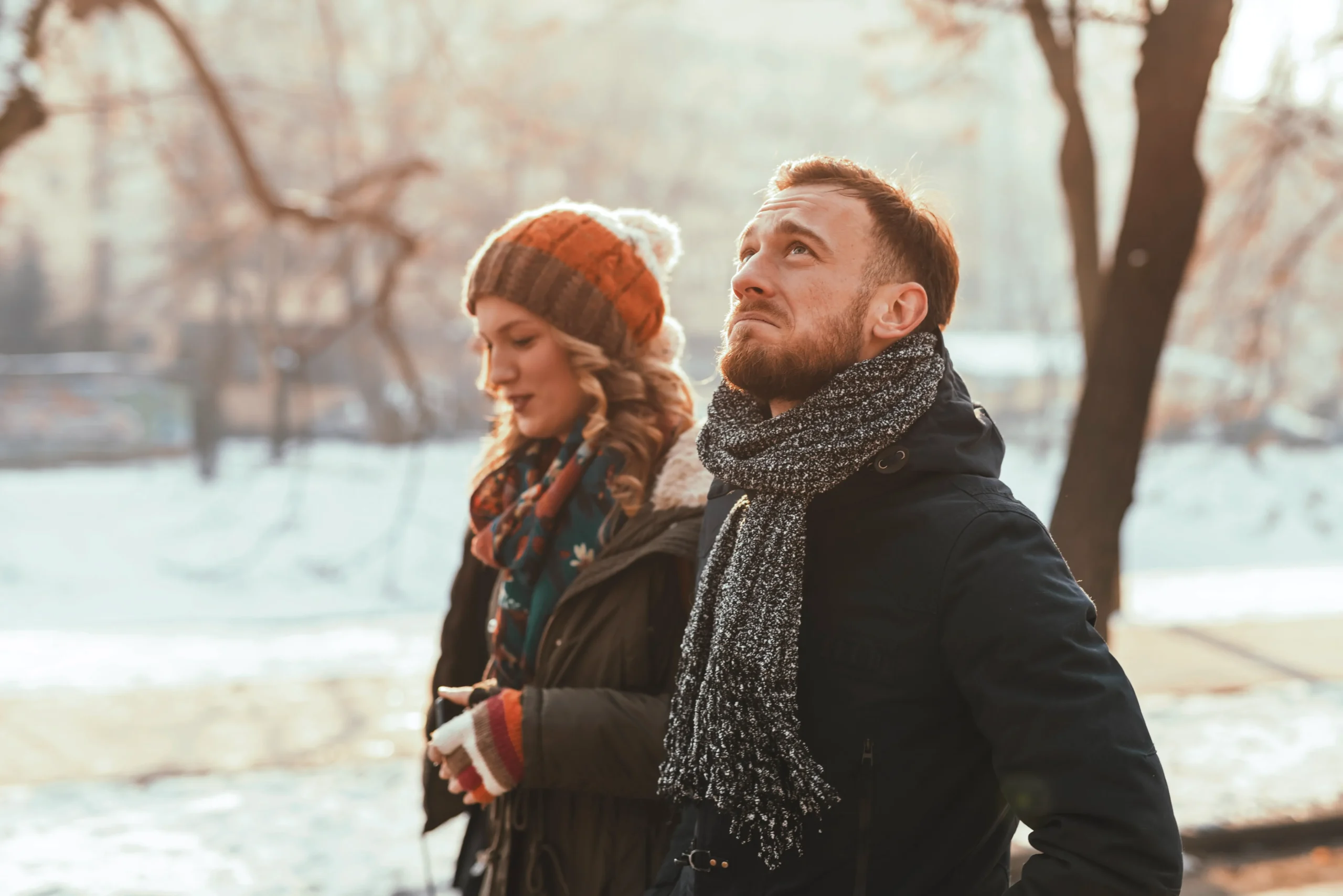 man and woman walking in park unhappy